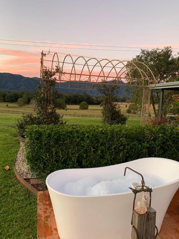 a bath tub in a yard with a roller coaster at Thamarra Cottage in Gleniffer