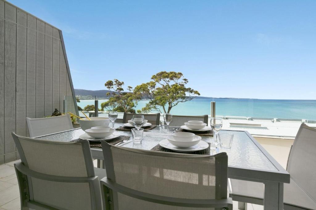 a dining table and chairs with a view of the beach at Apartment 25 Kalimna in Lorne