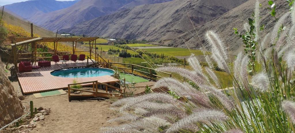 vistas a una piscina con montañas en el fondo en Cabañas "Terrazas de Orión" con Vista Panorámica en Pisco Elqui, en Pisco Elqui