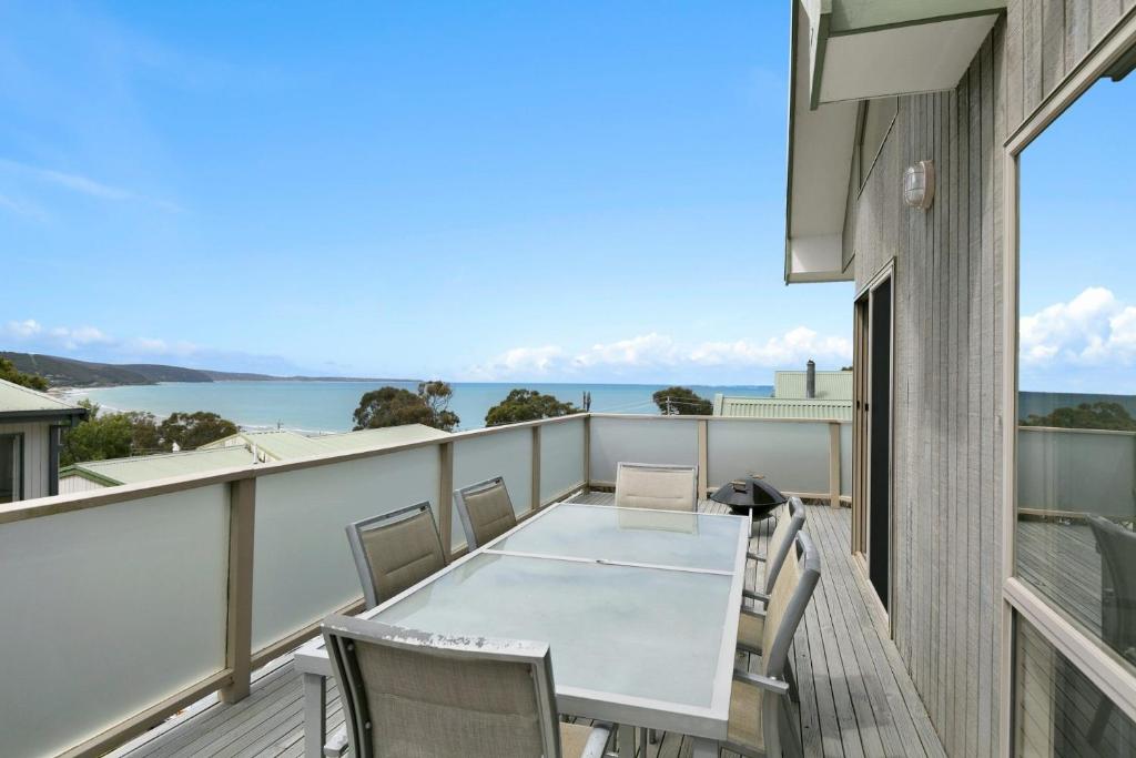 a balcony with a table and chairs and a view of the water at Lorne Central in Lorne