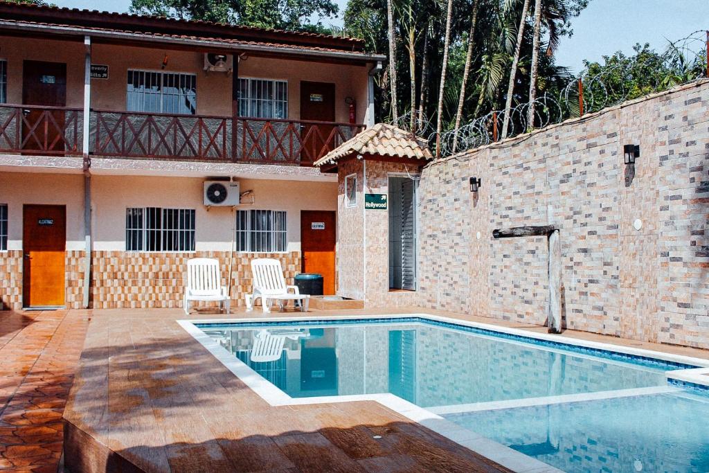 a swimming pool in front of a house at Solar Maresias Flats in Maresias