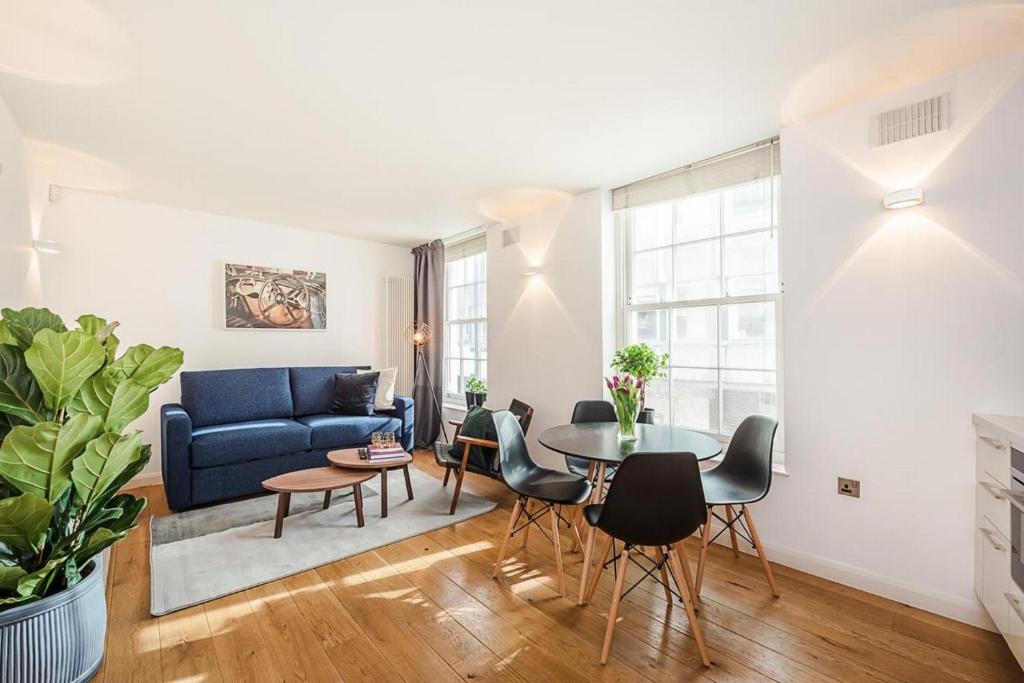 a living room with a blue couch and a table at Fantastic 1 Bedroom Flat Leicester Square West End in London