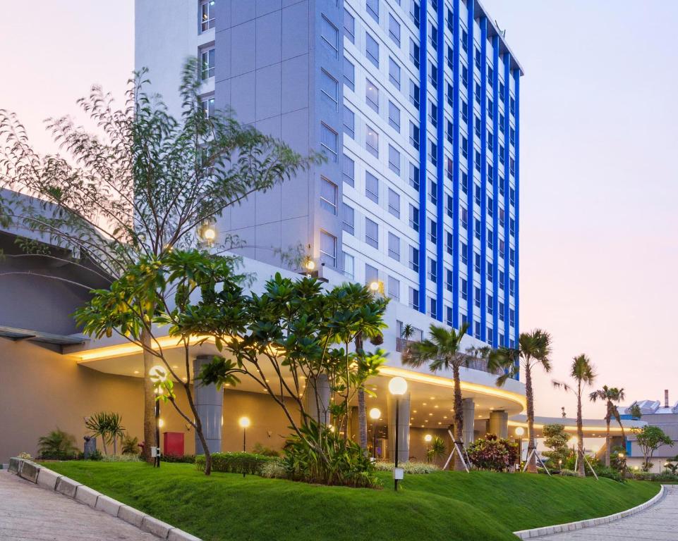 a view of a building with a lawn and trees at PrimeBiz Cikarang in Cikarang