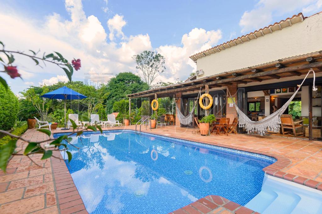 a swimming pool in a yard with a house at Fincas Panaca JAGÜEY 21 Grupo VIP in Quimbaya