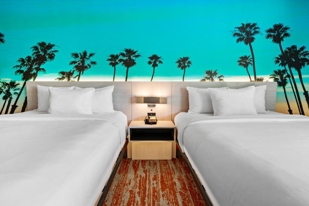 a hotel room with two beds and two lamps at Avania Inn of Santa Barbara in Santa Barbara