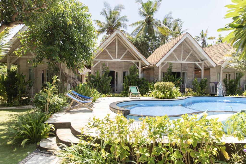 a house with a swimming pool in the yard at Coconut Village Guest House Lembongan RedPartner in Nusa Lembongan