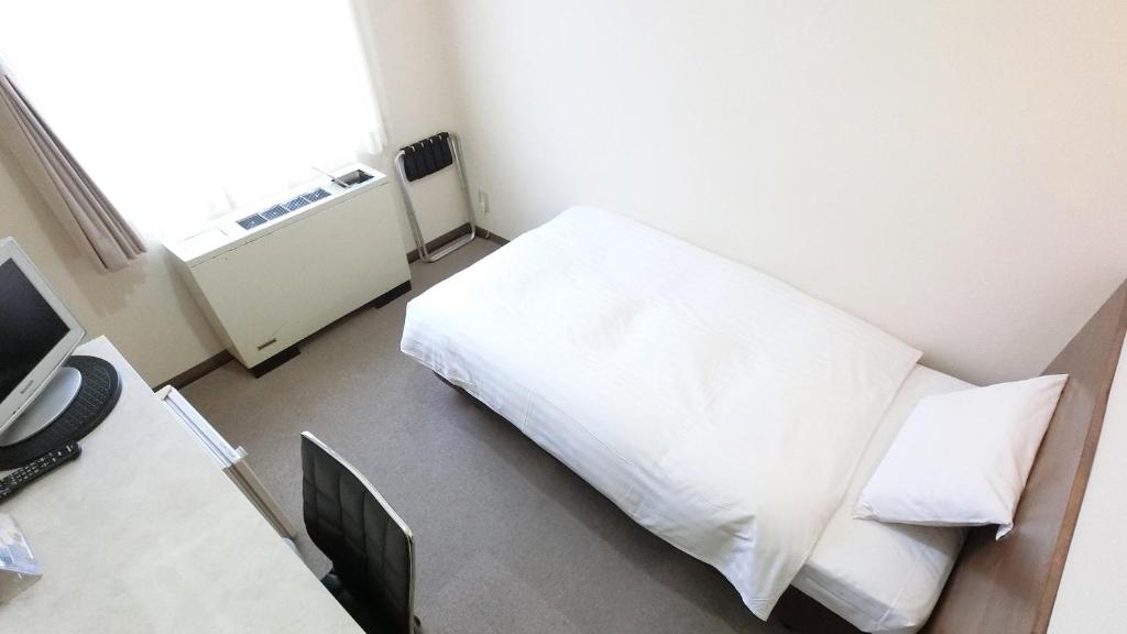 a bedroom with a white bed and a window at Honjo Grand Hotel Vacation STAY 35741 in Yurihonjo