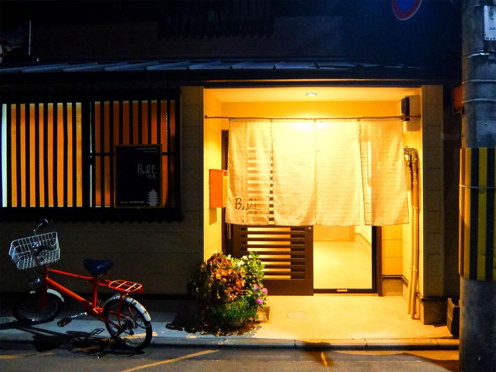 Una bicicleta estacionada fuera de una casa por la noche en Guesthouse Bell Fushimi, en Kioto