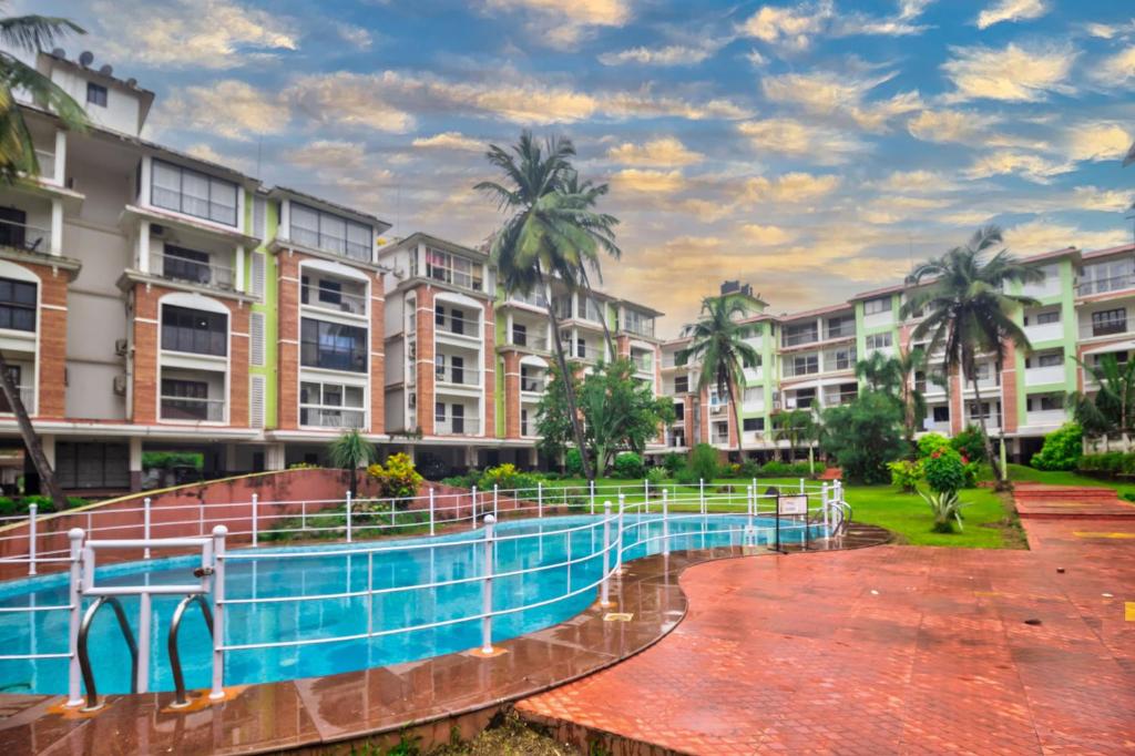 - une piscine en face de certains immeubles dans l'établissement Amazing Pool View Candolim Goa 2BHK Apartment, à Candolim