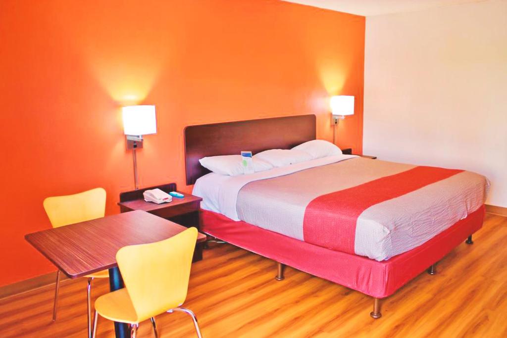 Habitación de hotel con cama, mesa y sillas en Key Inn Macedonia, en Macedonia