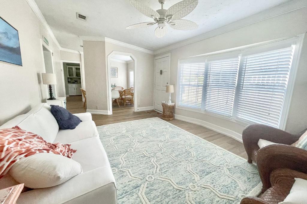 a living room with a white couch and a ceiling fan at Twin Lakes Cottage in Panama City Beach