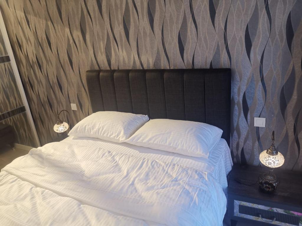 a bedroom with a white bed with a black headboard at My G yoo Apartment #1 in Istanbul