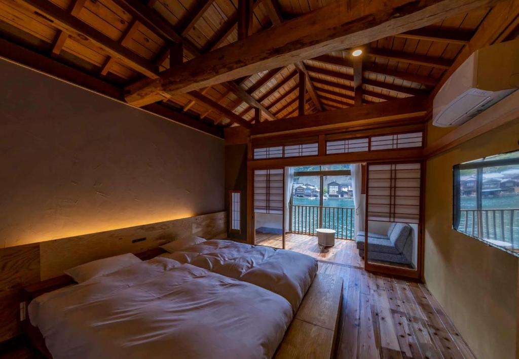 舟宿　壱 في Ine: غرفة نوم بسريرين في غرفة ذات أرضيات خشبية