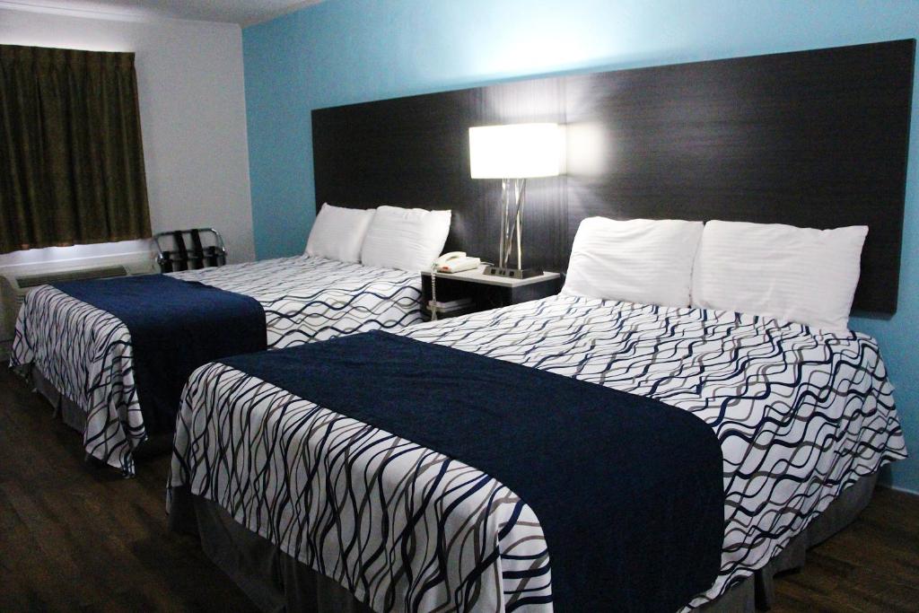 a hotel room with two beds and a large headboard at TexInn Motel New Boston in New Boston