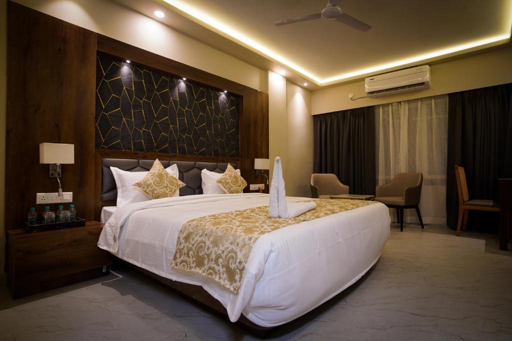 a hotel room with a large white bed and a room at The Adventure Luxury Hotels in Bhubaneshwar