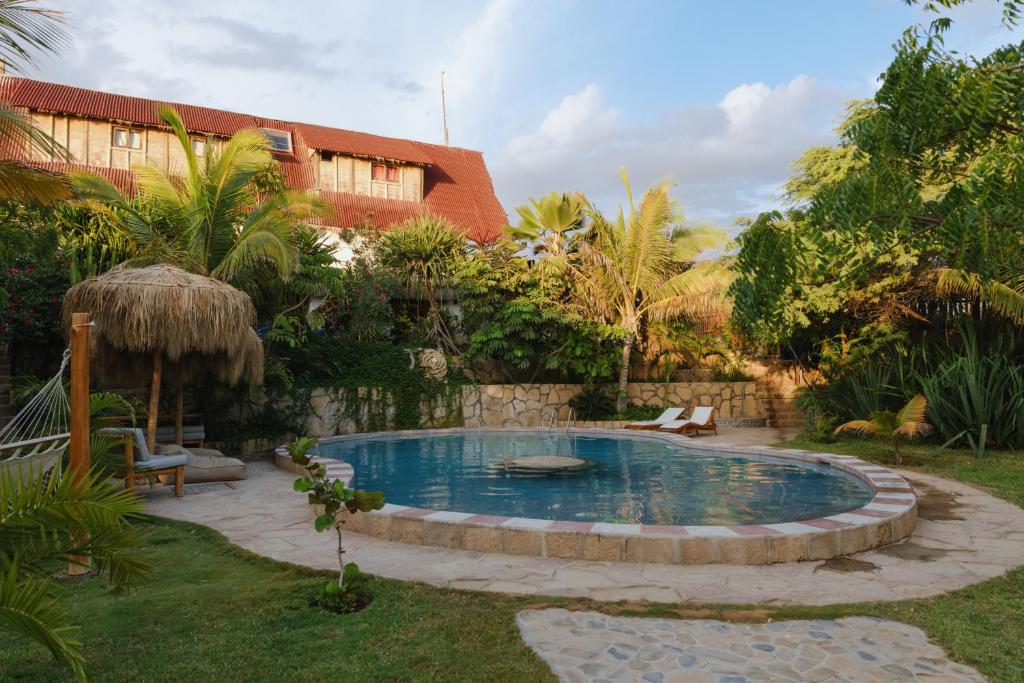 una piscina en un patio con una casa en La Fragata en Vichayito