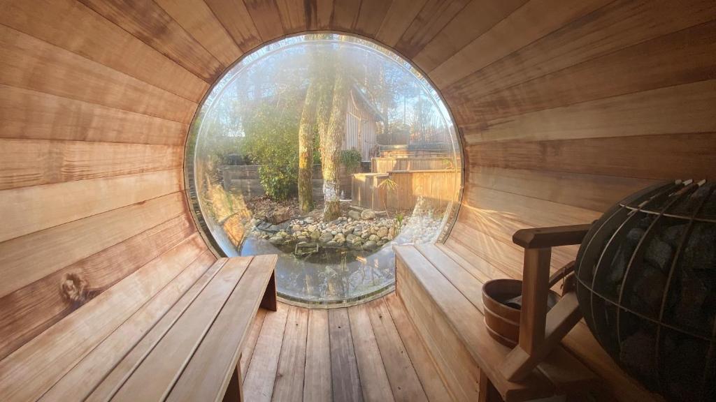 ein rundes Fenster in einer Sauna mit Teich darin in der Unterkunft L 58 LODGE de LUXE in Lège-Cap-Ferret