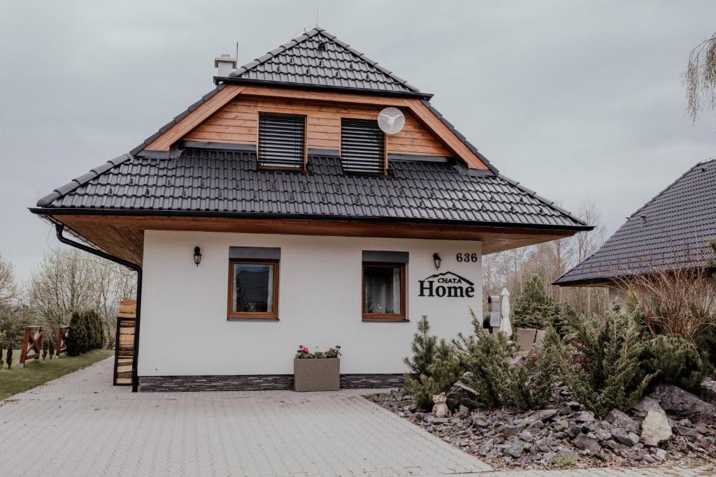 ein Haus mit einem Dach mit einem Hausschild drauf in der Unterkunft Chata HOME Stará Lesná in Stará Lesná