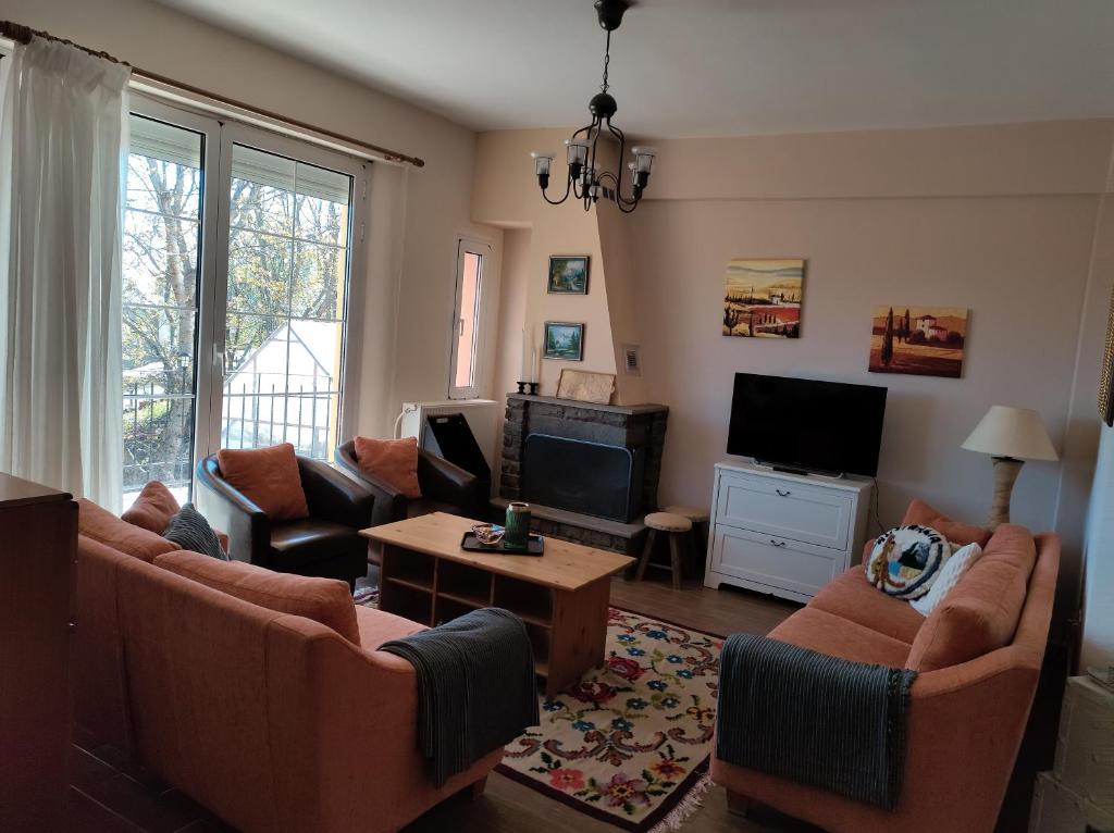 ein Wohnzimmer mit Sofas und einem Flachbild-TV in der Unterkunft Estel 2bedroom villa with fireplace in Grevena