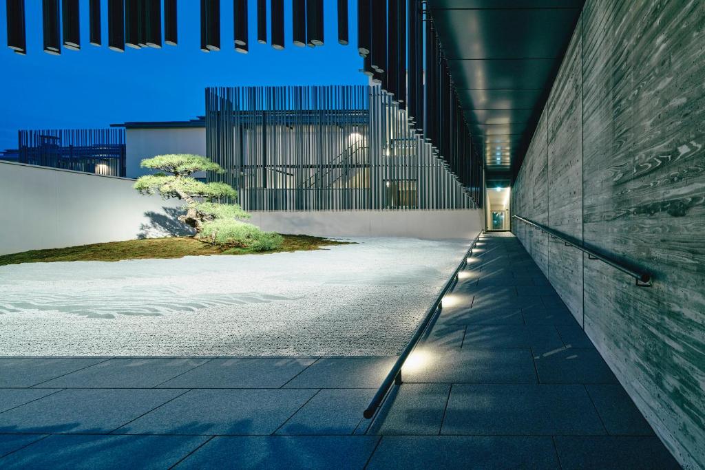 a hallway of a building with lights on the side at MUNI KYOTO by Onko Chishin in Kyoto