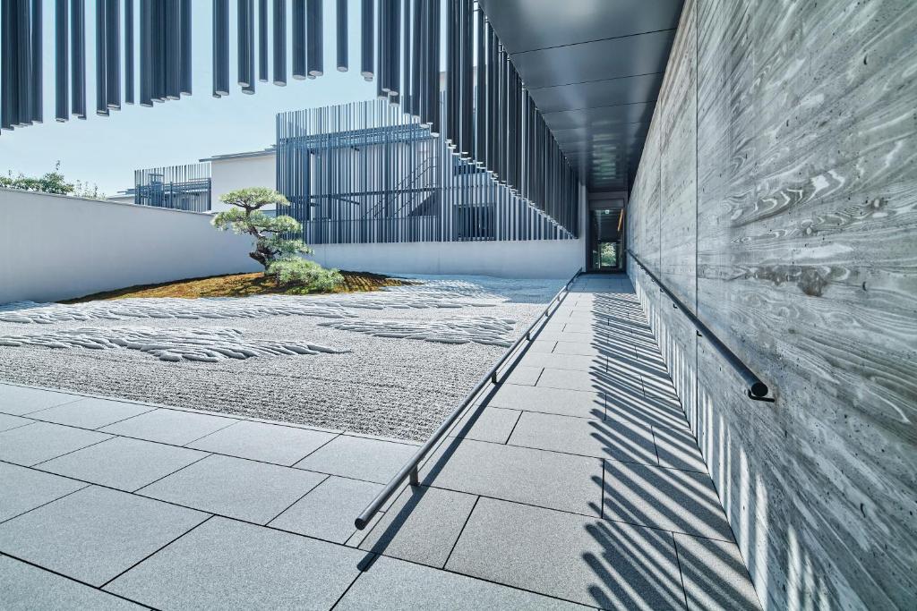 a hallway of a building with a tree in it at MUNI KYOTO by Onko Chishin in Kyoto