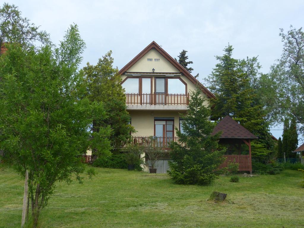 una casa en una colina con árboles delante de ella en House Elisabeth Balaton en Vonyarcvashegy
