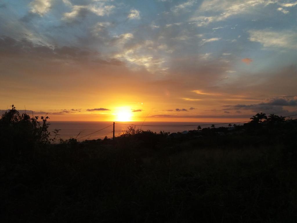 um pôr-do-sol com o pôr-do-sol sobre o oceano em Ticase Colibris em Saint-Leu