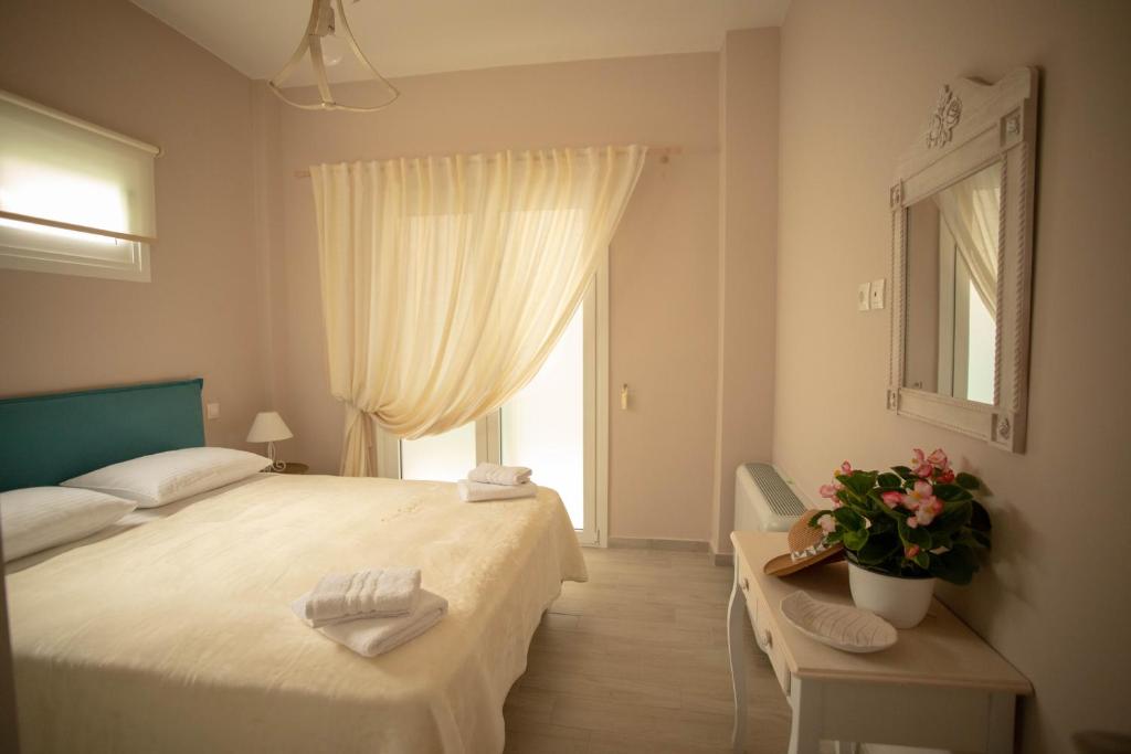 a bedroom with a large bed and a window at SantaCara City Apartment in Lefkada Town