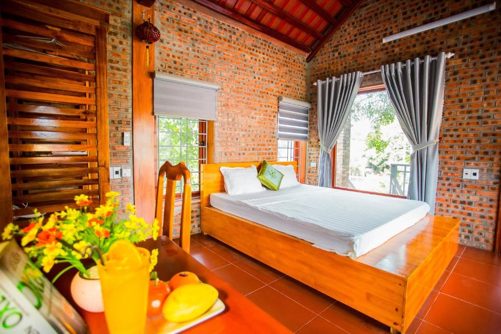 a bedroom with a bed and a table with flowers at Ninh Binh Mountain View Homestay & Restaurant in Ninh Binh