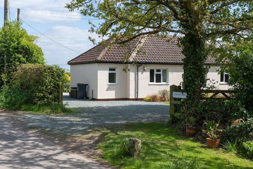 a white house with a driveway in front of it at Chase Lodge, Kenilworth, Family Sized Cottage With free Wifi in Kenilworth