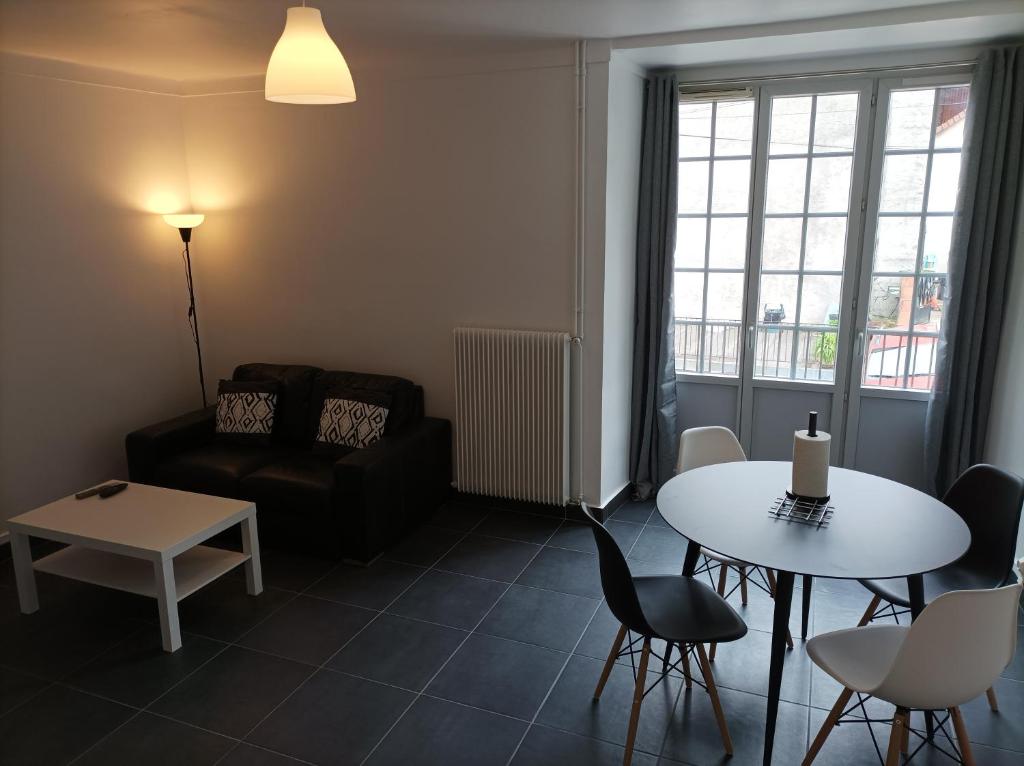 - un salon avec une table et un canapé dans l'établissement O'Couvent - Appartement 54 m2 - 1 chambre - A301, à Salins-les-Bains