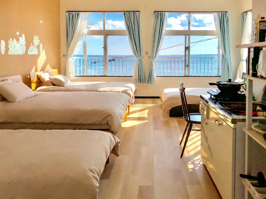 Habitación con 4 camas y cocina con ventanas. en Azama Ocean View Terrace, en Azama