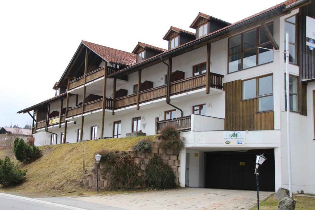 a large white building with a large garage at Apartement 270 Mitterdorf in Mitterfirmiansreut
