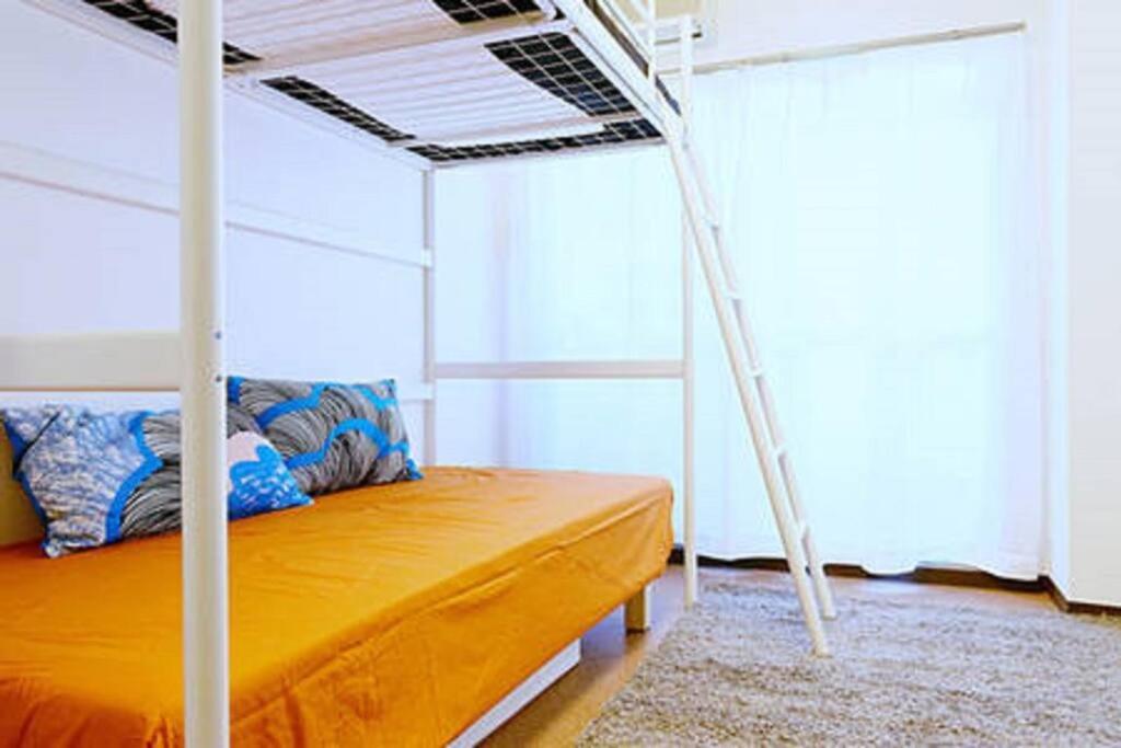 a bedroom with an orange bed with a ladder at it senriyama 101 in Senriyama