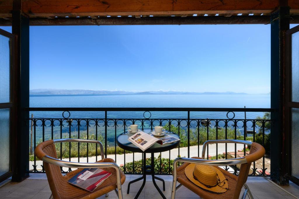 een tafel en stoelen op een balkon met uitzicht op de oceaan bij Batelo - Adults Only in Benitses