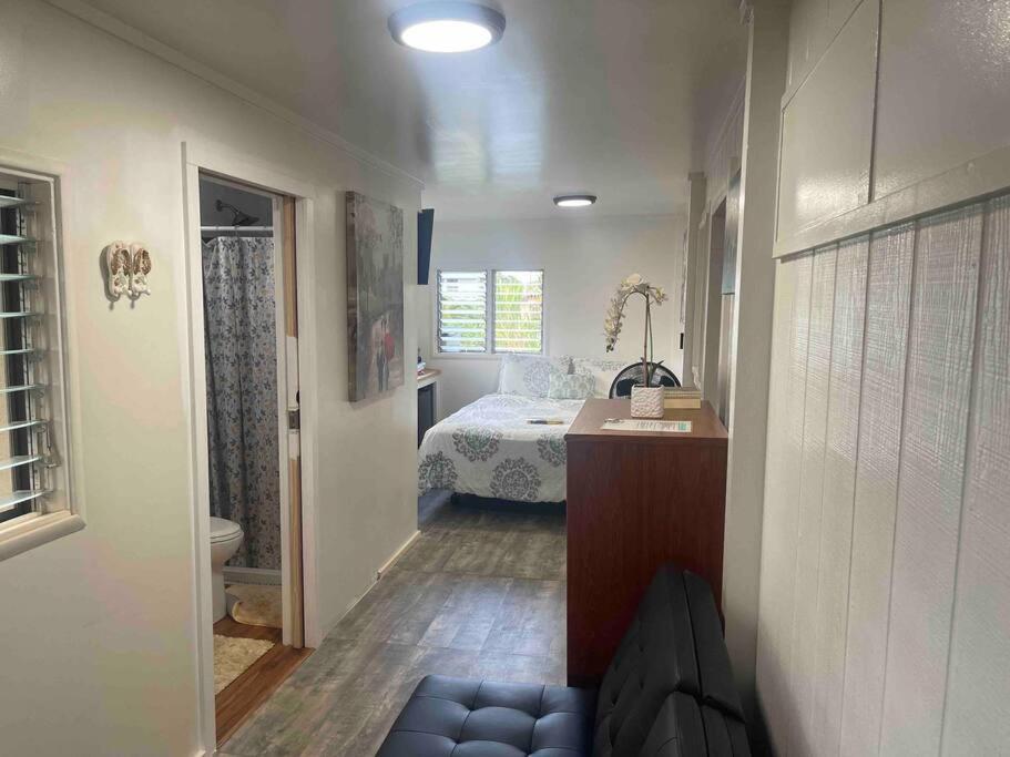 a small bedroom with a bed and a bathroom at Tavares house in Waialua