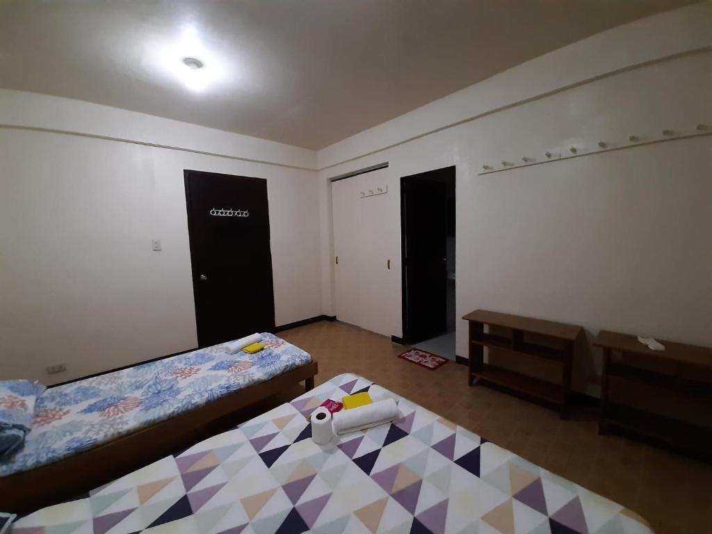 Zimmer mit 2 Betten und einem Tisch in der Unterkunft Sanctuary Transient House Bacolod in Bacolod City