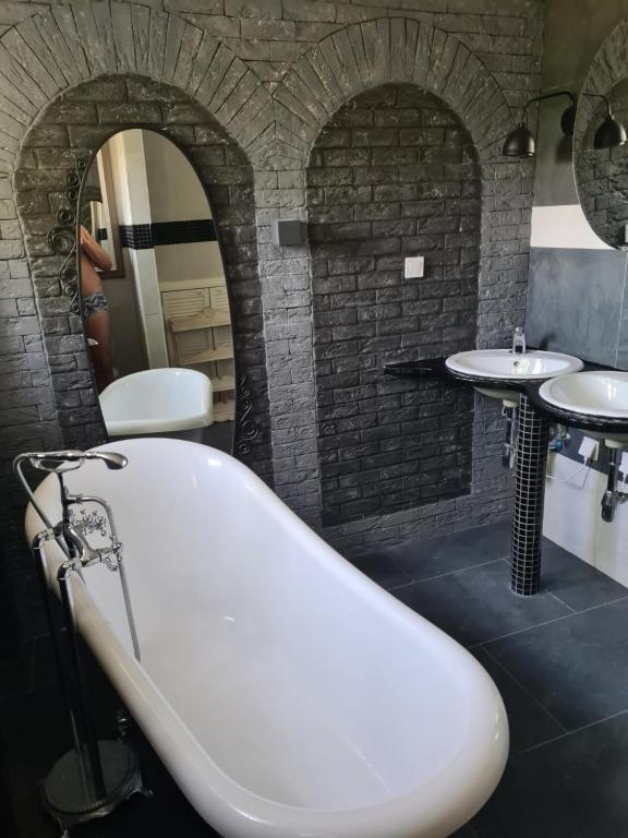uma casa de banho com 2 lavatórios e uma banheira em Airport Rooms em Praga
