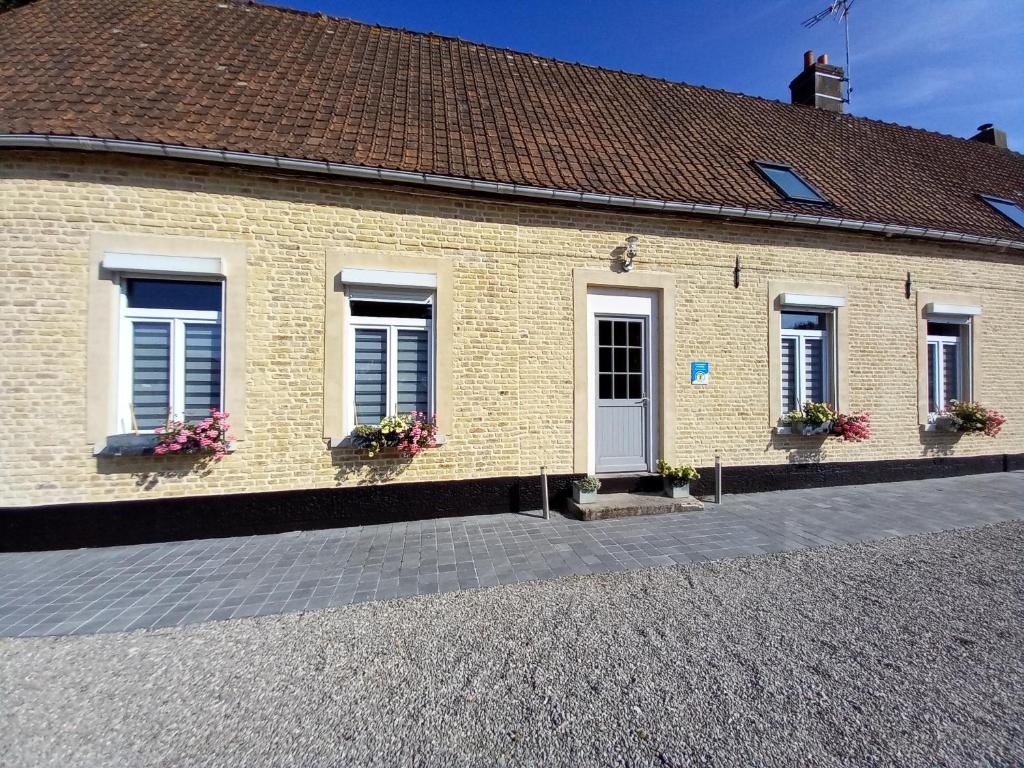 ein Backsteingebäude mit Fenstern und Blumen in den Fensterkästen in der Unterkunft La Cense Hebron in Ardres