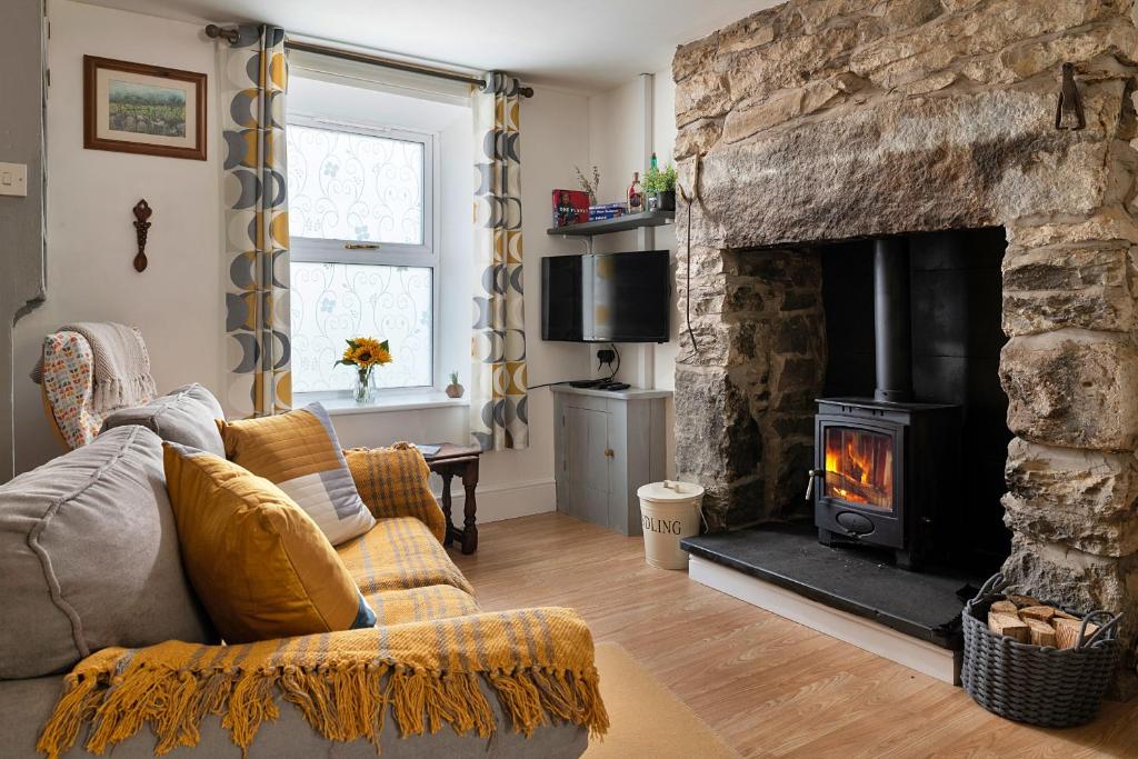 a living room with a stone fireplace and a couch at Finest Retreats - Cysgod y Graig in Blaenau-Ffestiniog