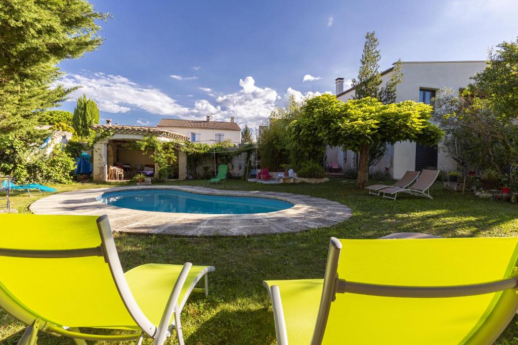 a yard with two chairs and a swimming pool at Suite Zen Grand Lit in Pierrelatte