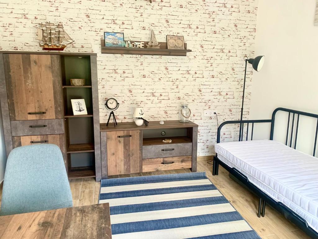 a room with two beds and a table and a wall at Öböl Apartman in Balatonboglár