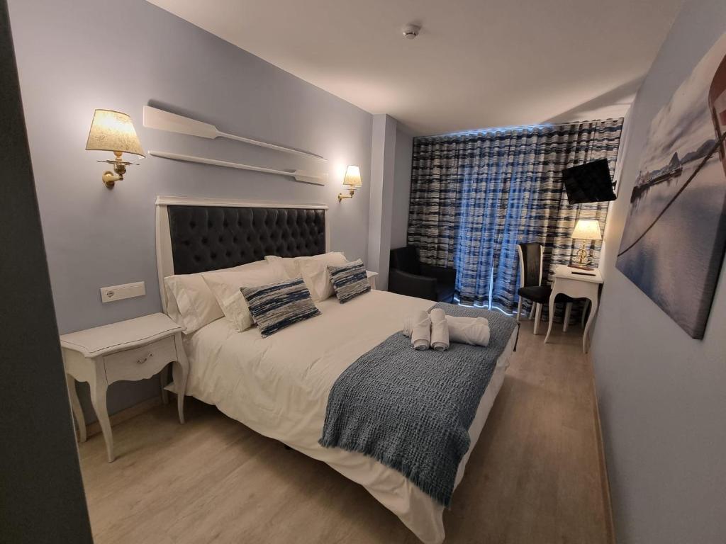 a bedroom with a bed and a desk and a window at Arha Santoña by Maile in Santoña