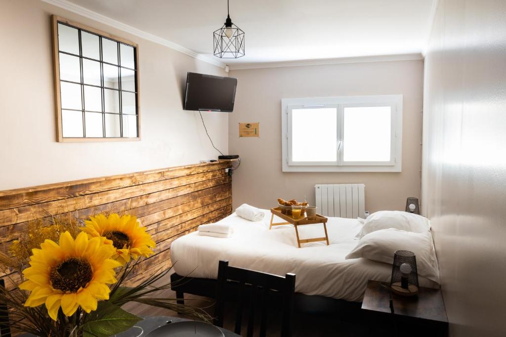 sypialnia z łóżkiem, stołem i słonecznikami w obiekcie Le Petit Mondi w mieście Mareuil-sur-Cher