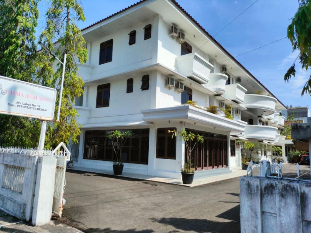 Biały budynek z znakiem przed nim w obiekcie Wisma Hari Kota w mieście Medan