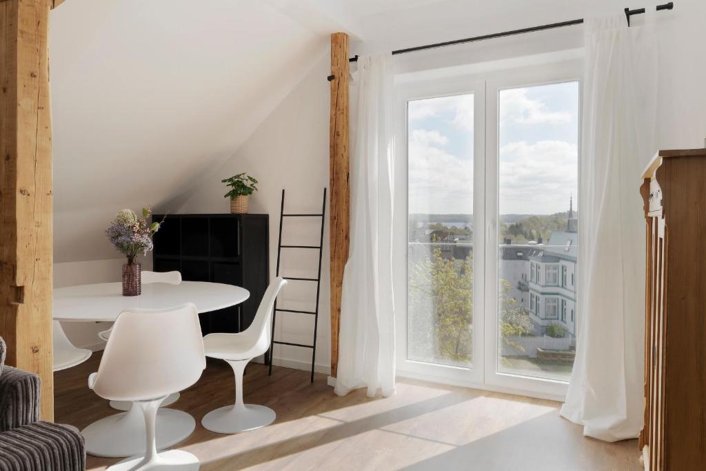 a living room with a table and a large window at Schöner Ausguck in Malente