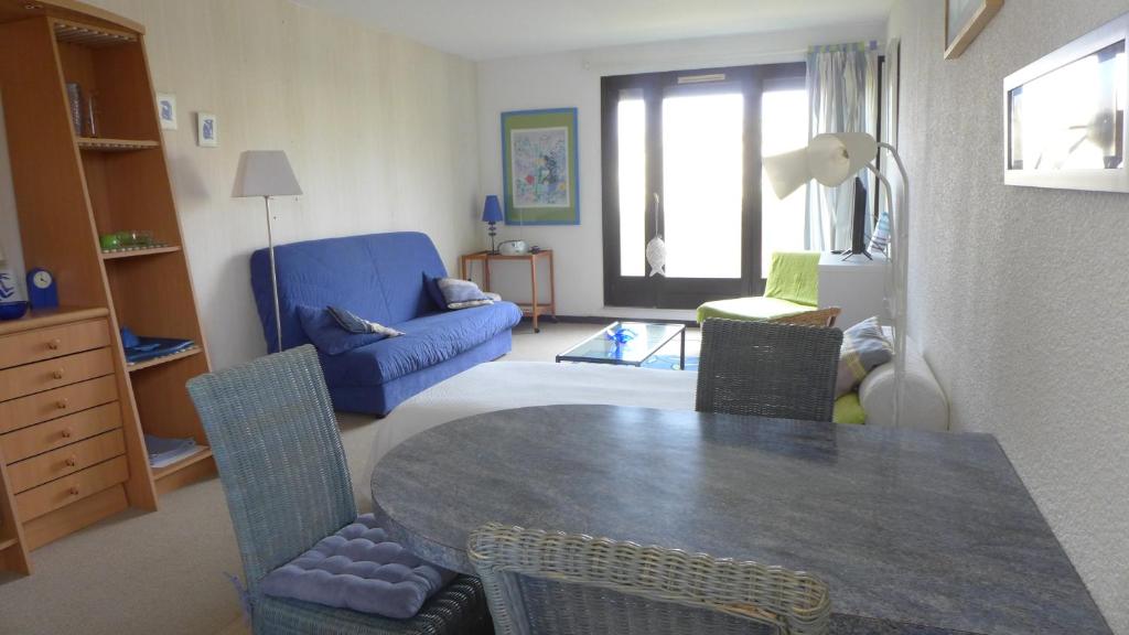 a living room with a table and a blue couch at Réf 422, Seignosse océan, Studio proche plage et centre , 2 personnes in Seignosse