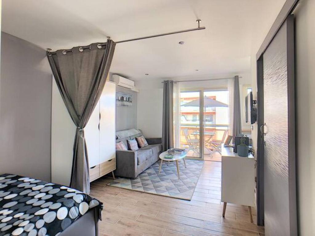 une chambre avec un lit et un salon dans l'établissement Juan Les Pins Centre - Studio Neuf Avec Terrasse - 3 Mins Des Plages - Jazz Apartment, à Antibes