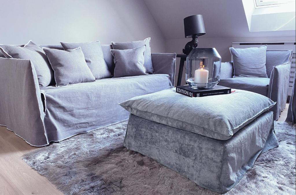 ein Wohnzimmer mit einem Sofa und einer Kerze auf einer Ottomane in der Unterkunft 21oaks / Cozy-Luxury / Boutique Home / Frankfurt in Ortenberg