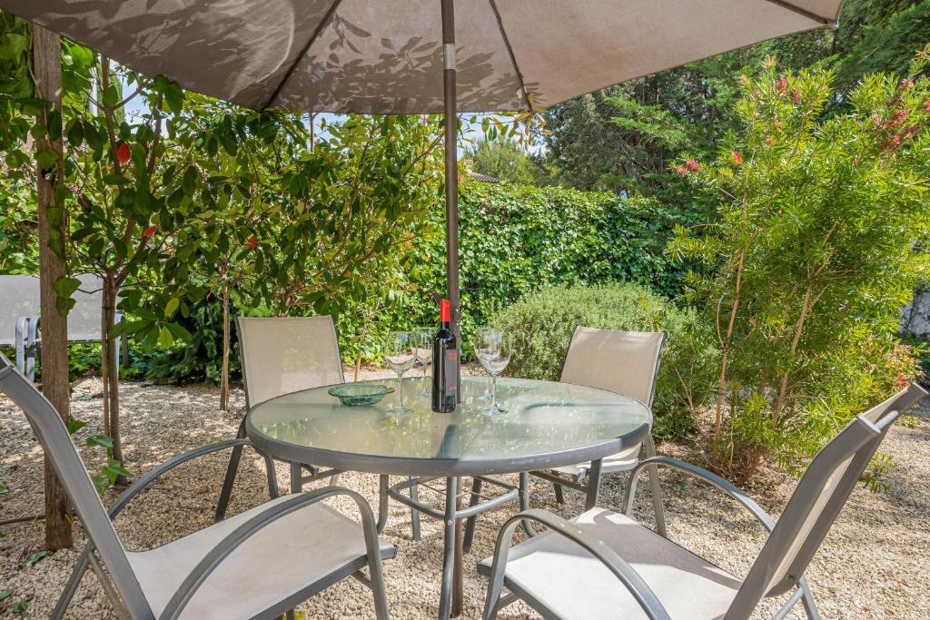a glass table with chairs and an umbrella at Bonanova 20 in Palma de Mallorca